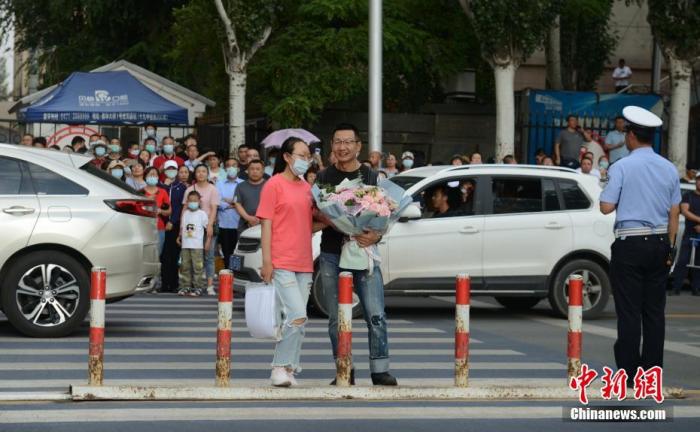 7月8日，内蒙古呼和浩特市一高考考点，考生结束考试后收到来自家长的鲜花。 中新社记者 刘文华 摄